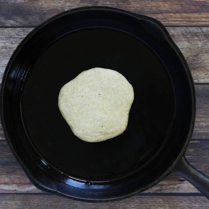 partially cooked pancake in black cast iron pan