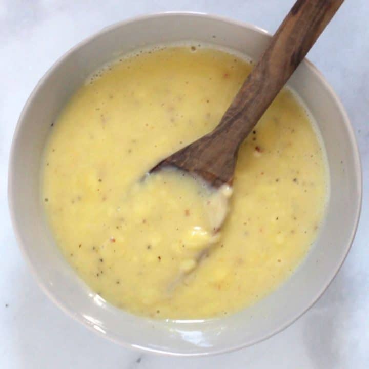 creamy salad dressing in beige bowl with wooden spoon