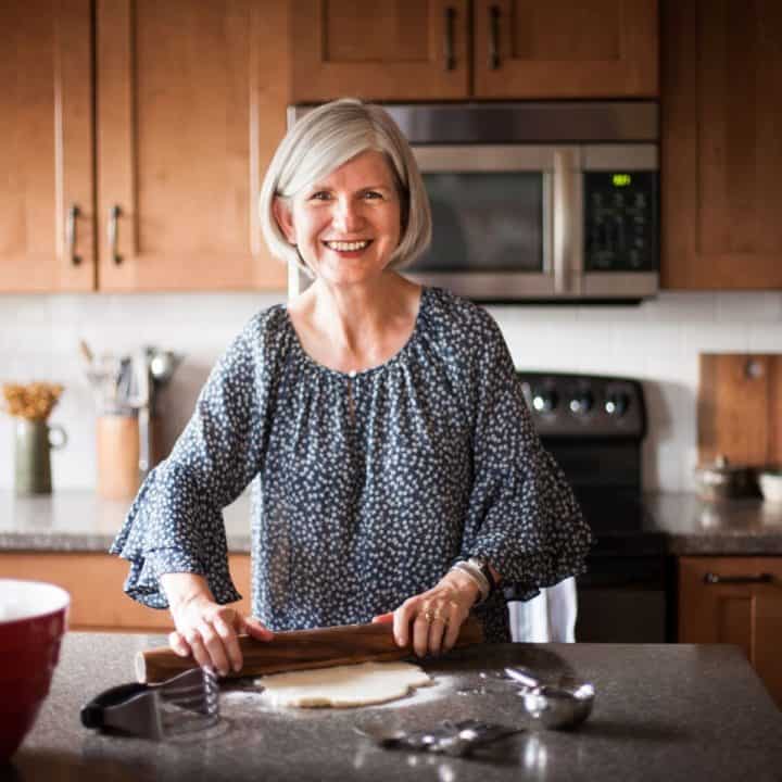 Cathy rolling out a pie crust in kitchen