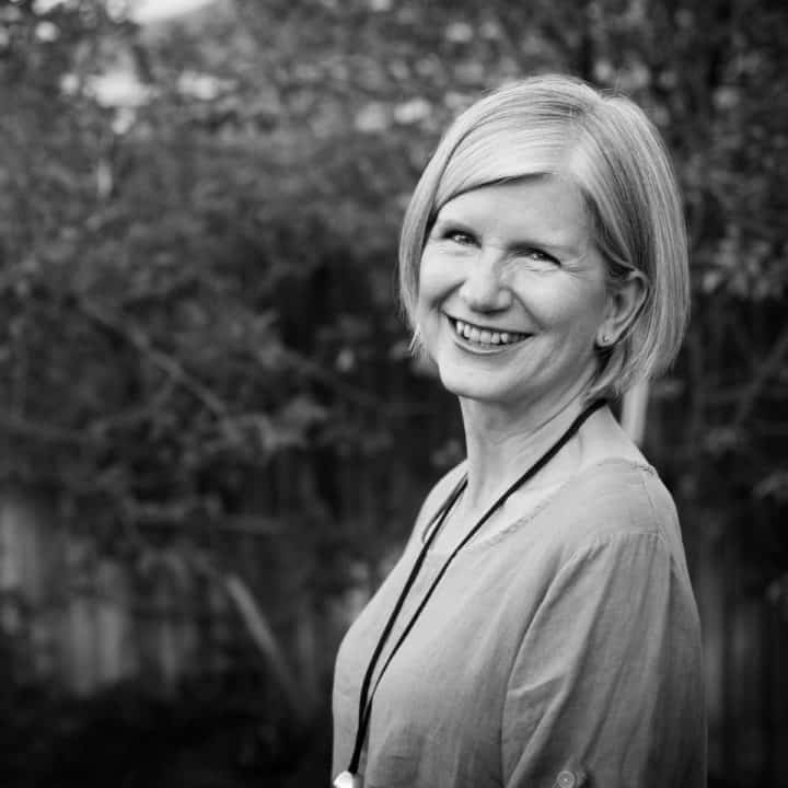 black and white photo of Cathy in front of leafy trees