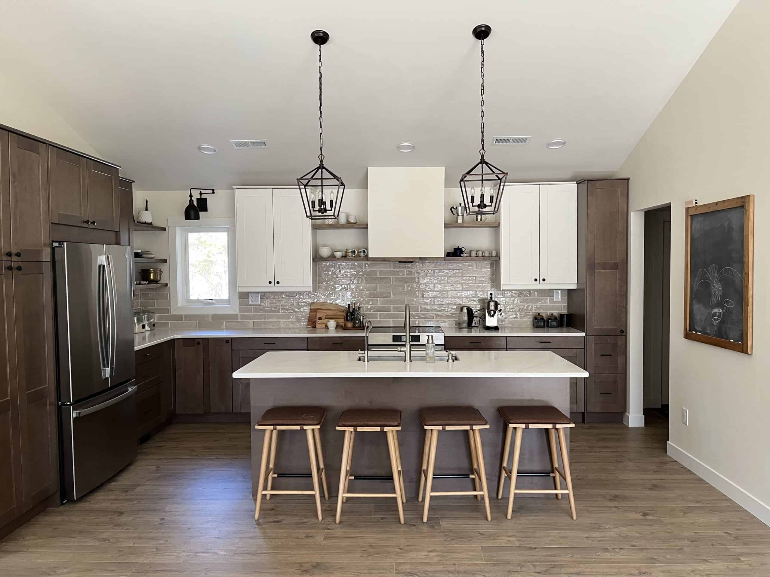 kitchen with dark wood cabinets and some white uppers, four stools at island counter.