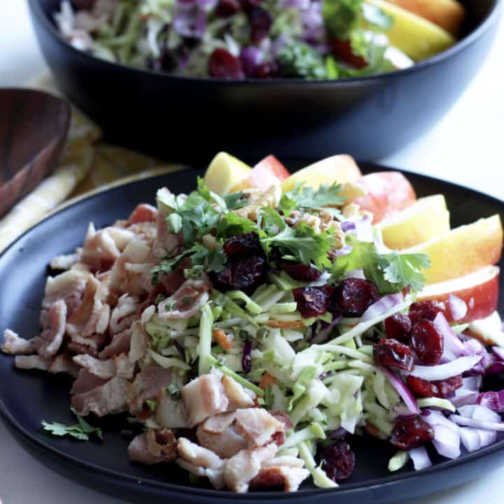 closeup of broccoli salad with cilantro, dried cranberries, and walnuts on top