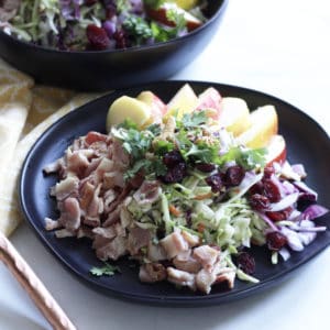 chopped bacon, apples, cabbage, and broccoli on black plate