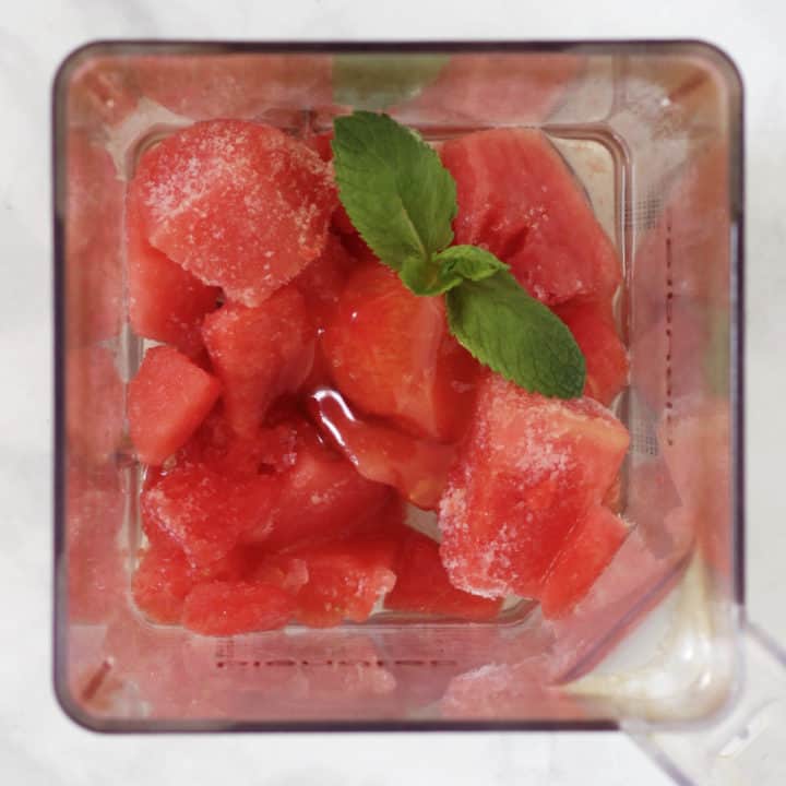 chunks of watermelon and sprig of mint in blender jar