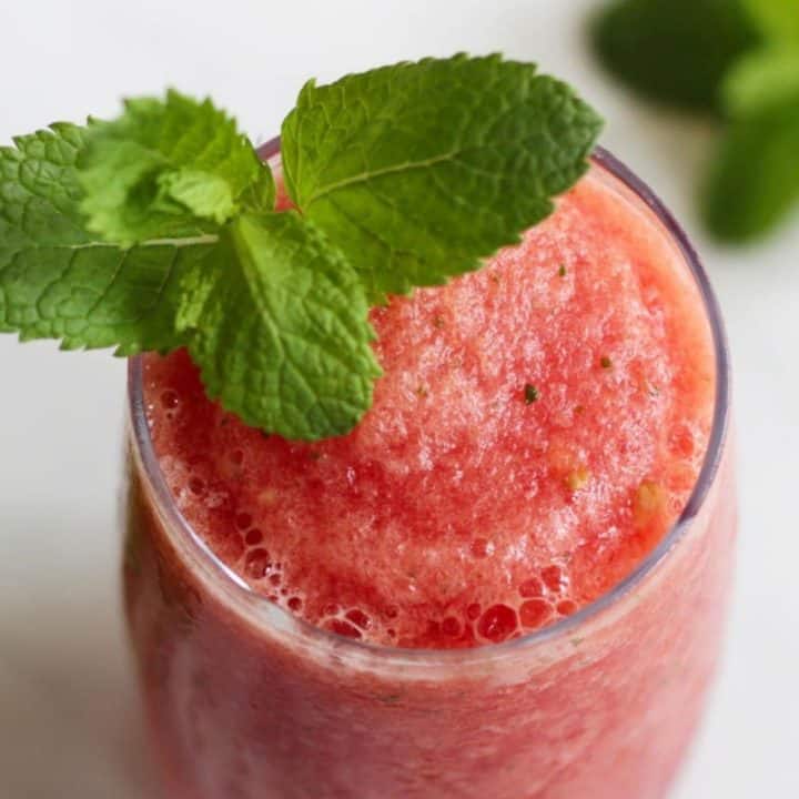 closeup of pink slushie garnished with mint leaves