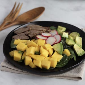 chunks of mango and avocado with roast beef and radishes viewed from an angle
