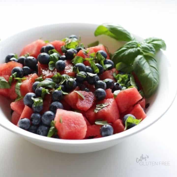 watermelon chunks, blueberries, and chopped basil in white bowl