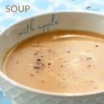 closeup of creamy golden butternut squash soup in white bowl with Pinterest text