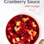 looking down on white bowl of cranberry sauce with chunks of sweet mango