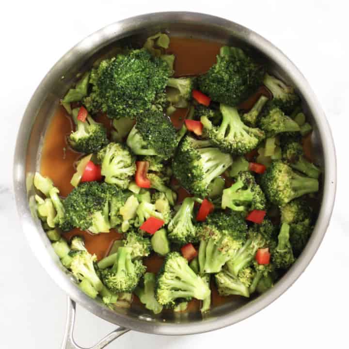 broccoli in pan with sauce and added red pepper