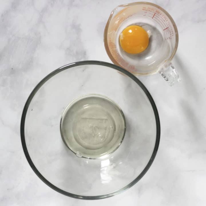 egg yolk in pyrex measuring cup and egg white in glass bowl