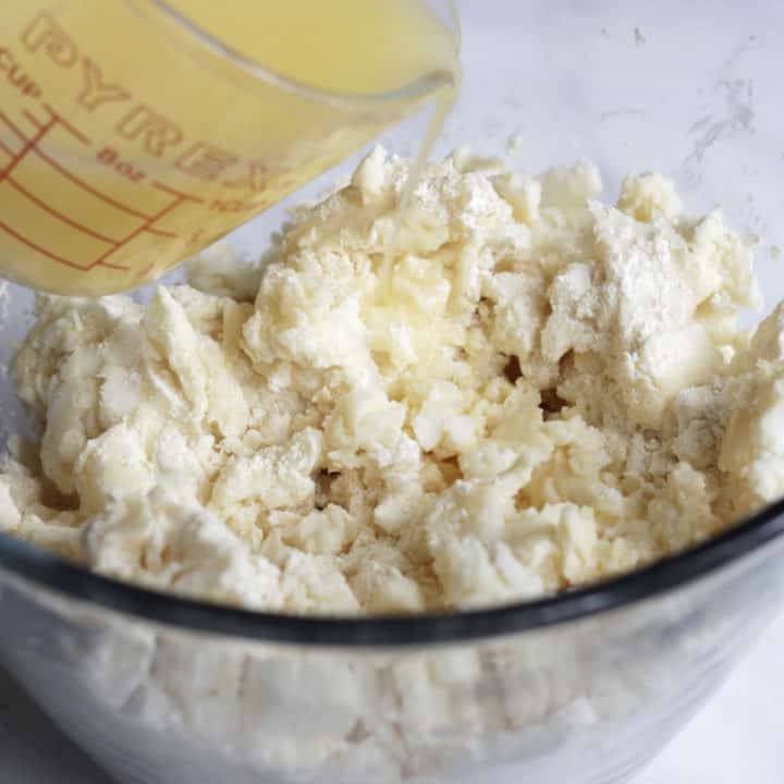 yellow liquid is poured over lumpy flour mixture