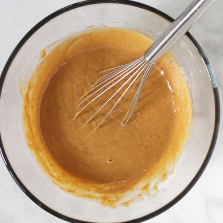 caramel-coloured thick liquid with whisk in glass bowl