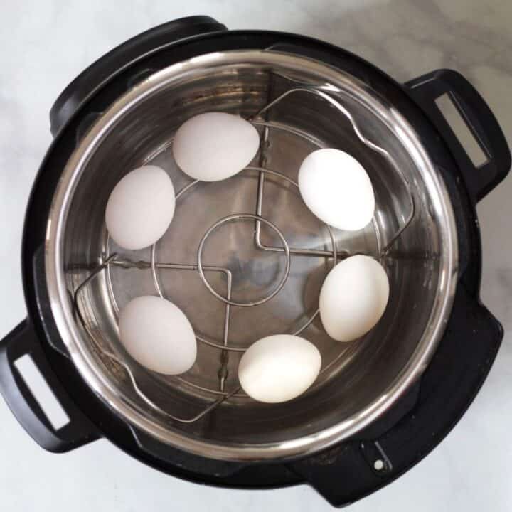 six eggs on trivet with water in Instant Pot