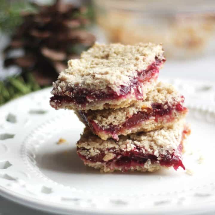 stack of three cranberry bars on white lacy plate
