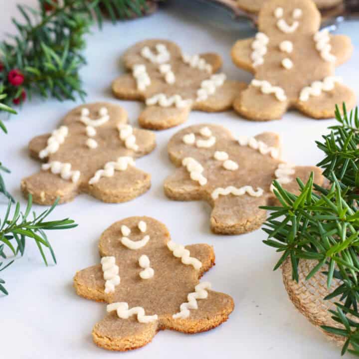 decorated gingerbread men scattered on white surface.