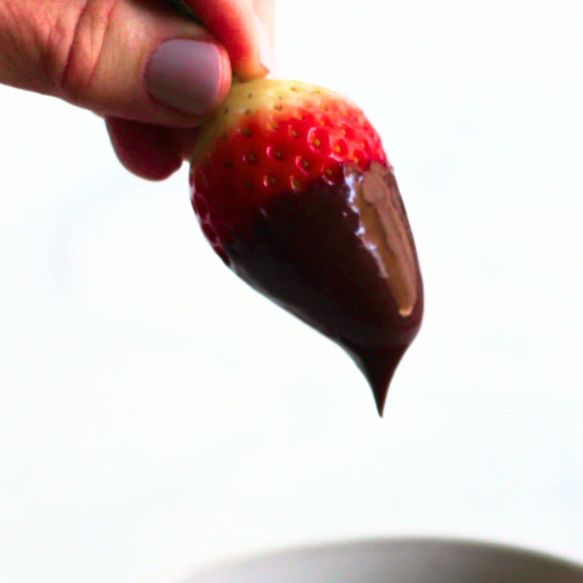 shiny chocolate ganache dripping from a strawberry.
