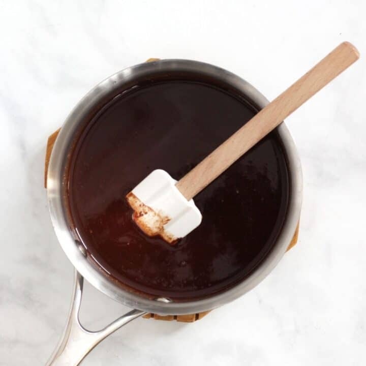 melted chocolate in small saucepan with a spatula resting in it