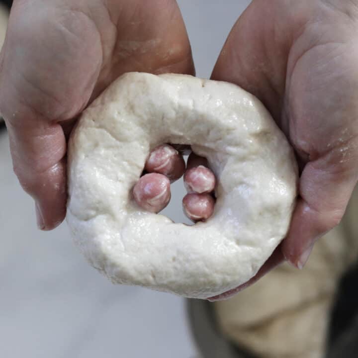 raw bagel held in hands