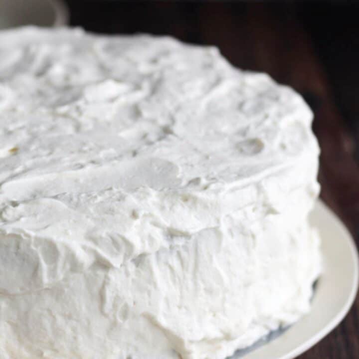 close up of white frosting on round cake