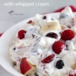 closeup of berries, grapes, apples, and bananas in whipped cream with title text