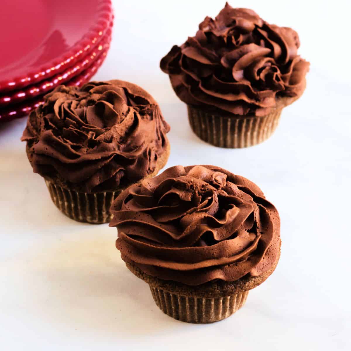 gluten-free chocolate cupcakes frosted with piped whipped chocolate ganache.
