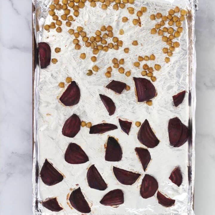 chickpeas and chunks of beet spread out on a foil-lined baking sheet