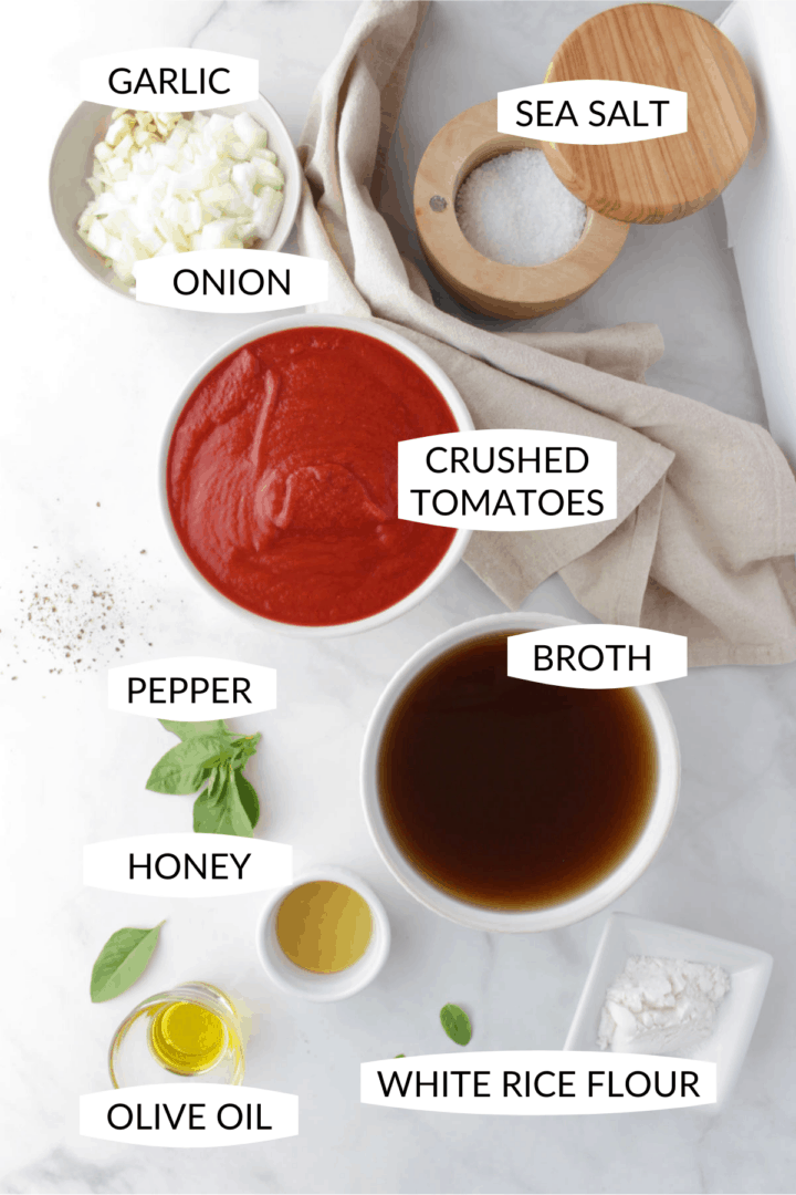 individual ingredients for tomato soup in small bowls with labels