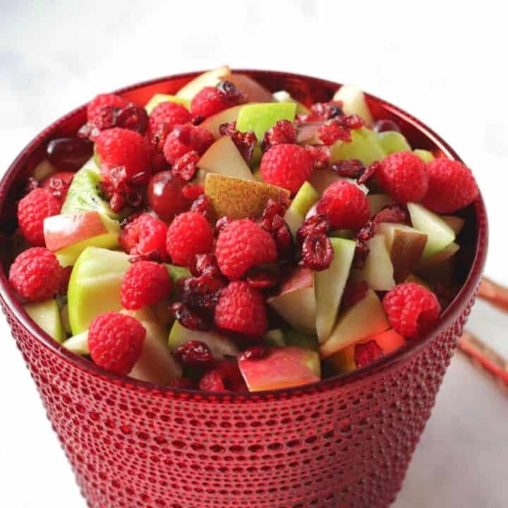 red and green fruit salad in red glass bowl