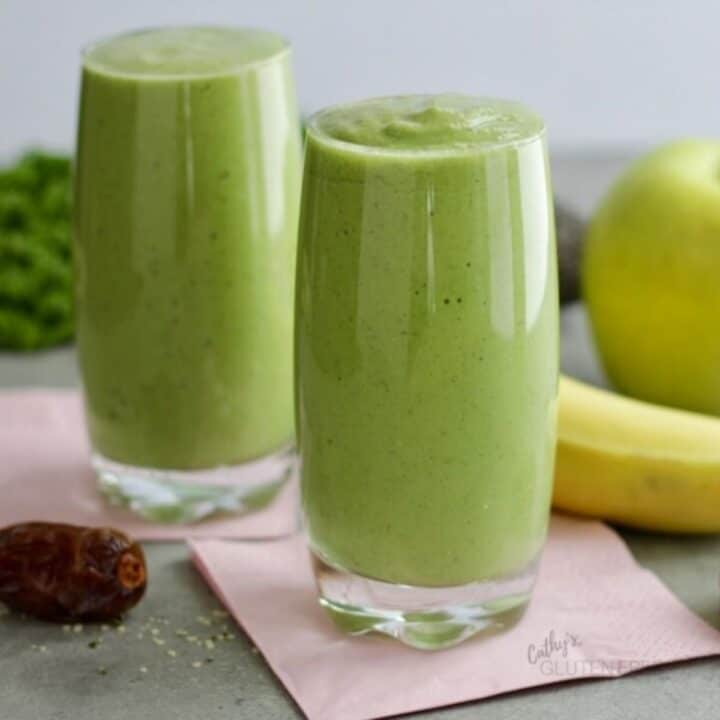 two glasses of healthy green smoothie on pink paper napkins