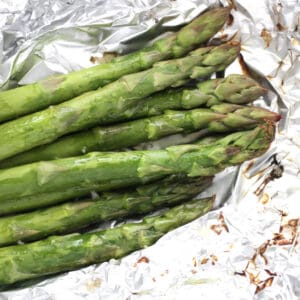 bright green spears of asparagus lying on crumpled foil.