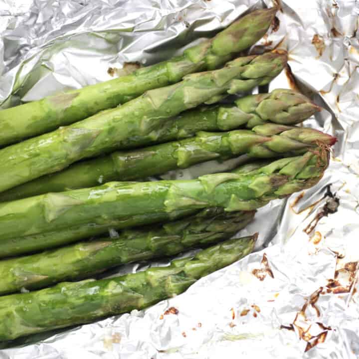 bright green asparagus with brown bits around the edges on crinkled foil.