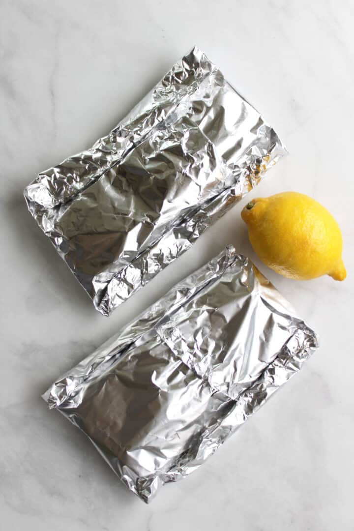 two rectangular foil-wrapped packets and a lemon.