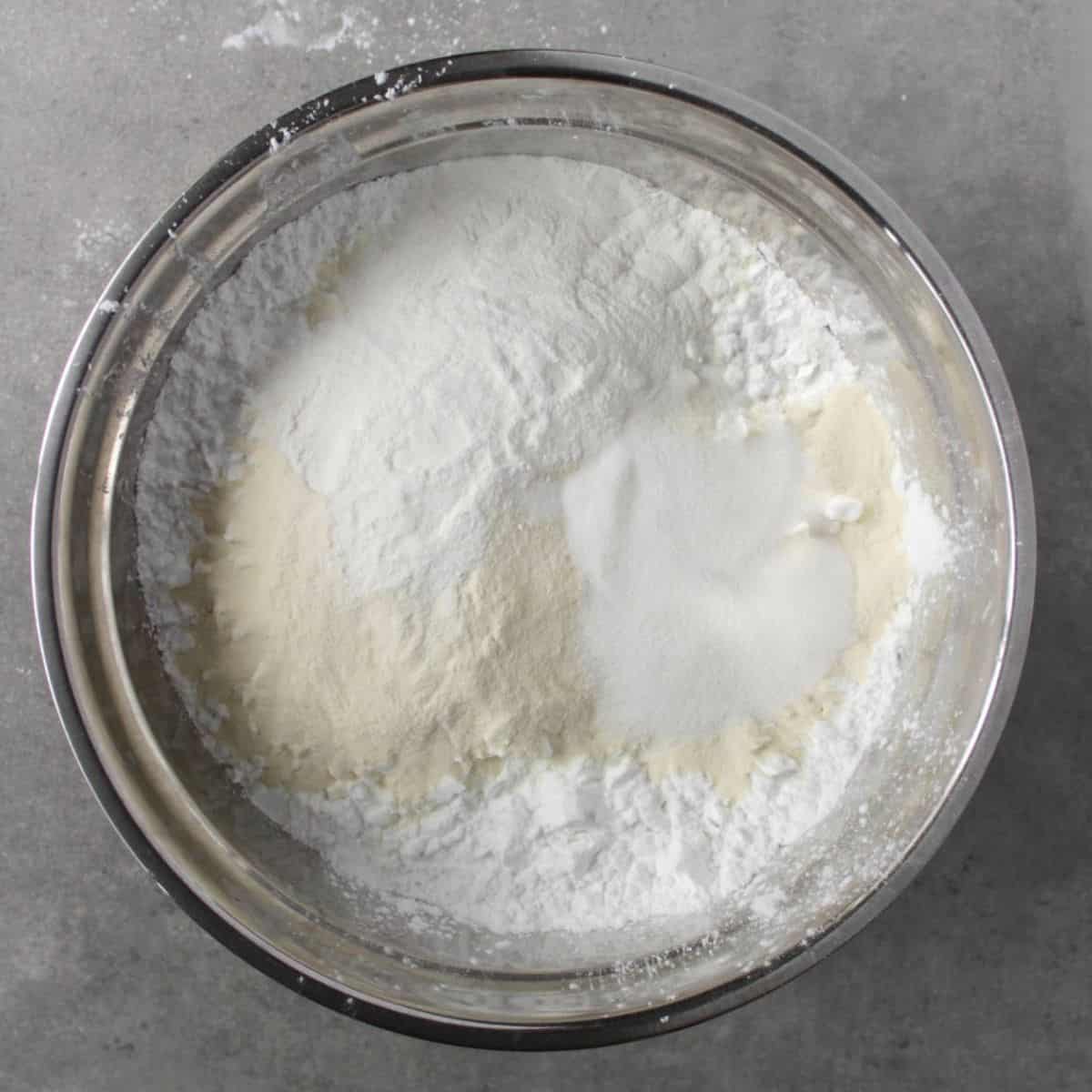 flours in varying shades of white in a stainless steel bowl.