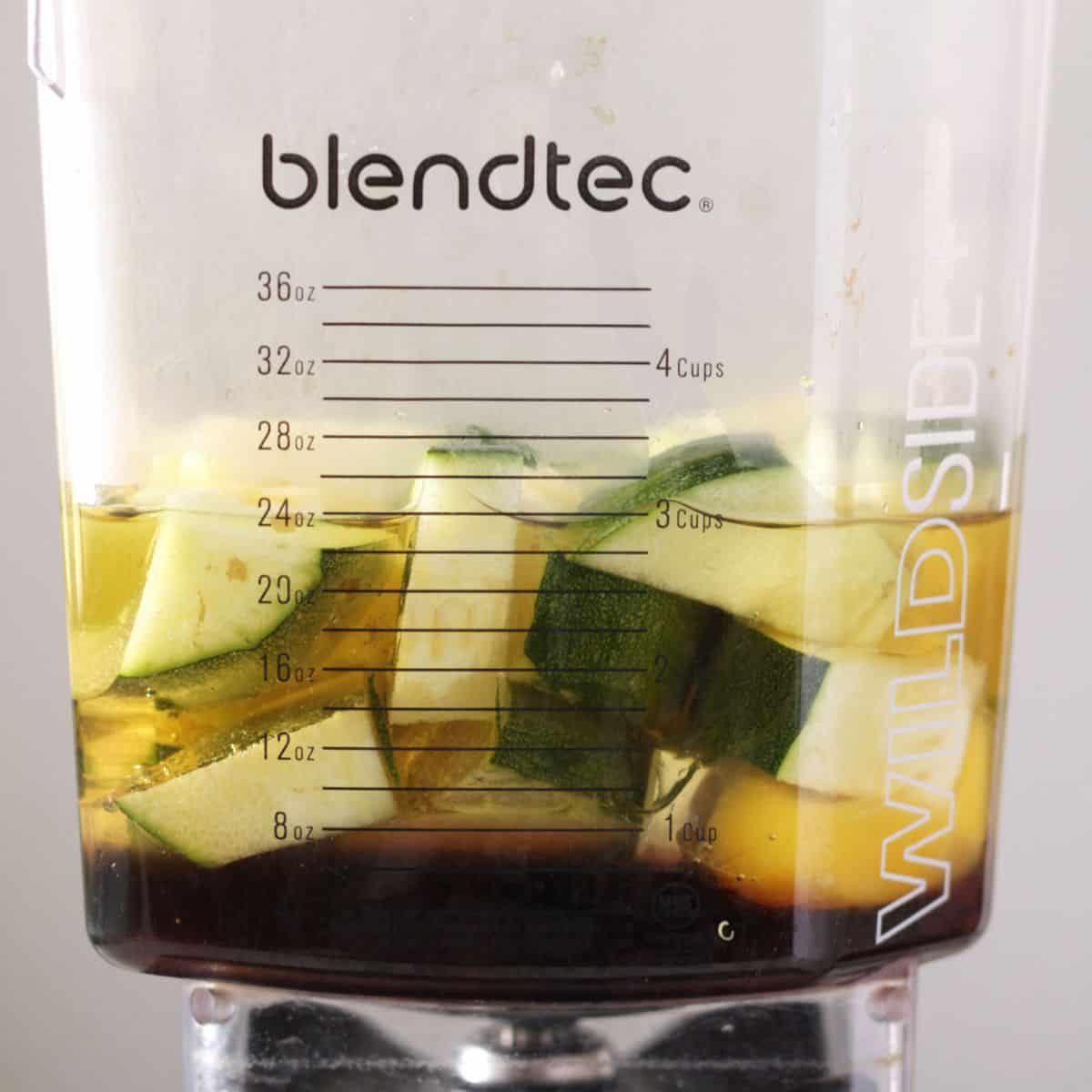 chunks of zucchini with eggs, oil, and maple syrup in Blendtec blender jar.