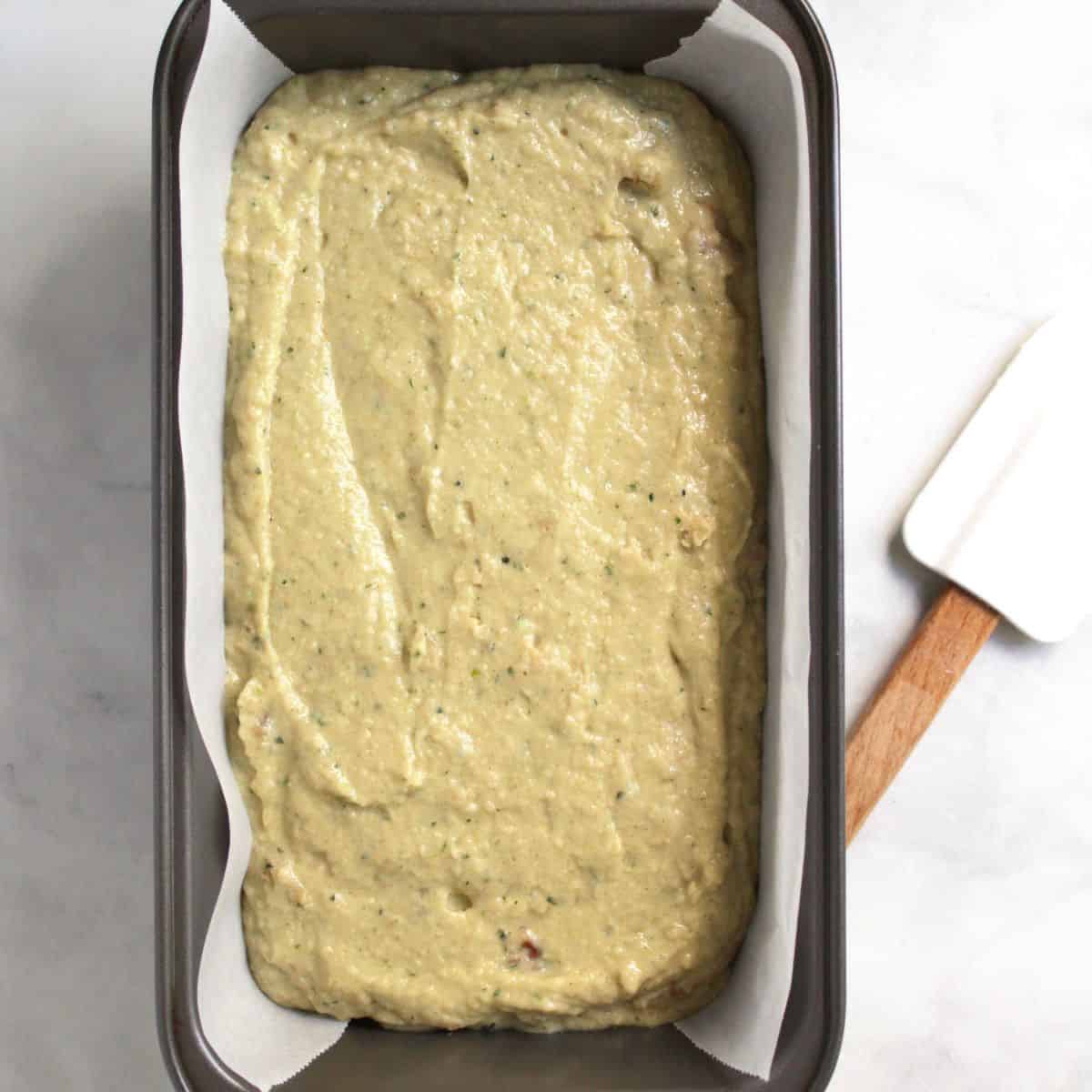 moist batter spread into parchment paper-lined loaf pan.