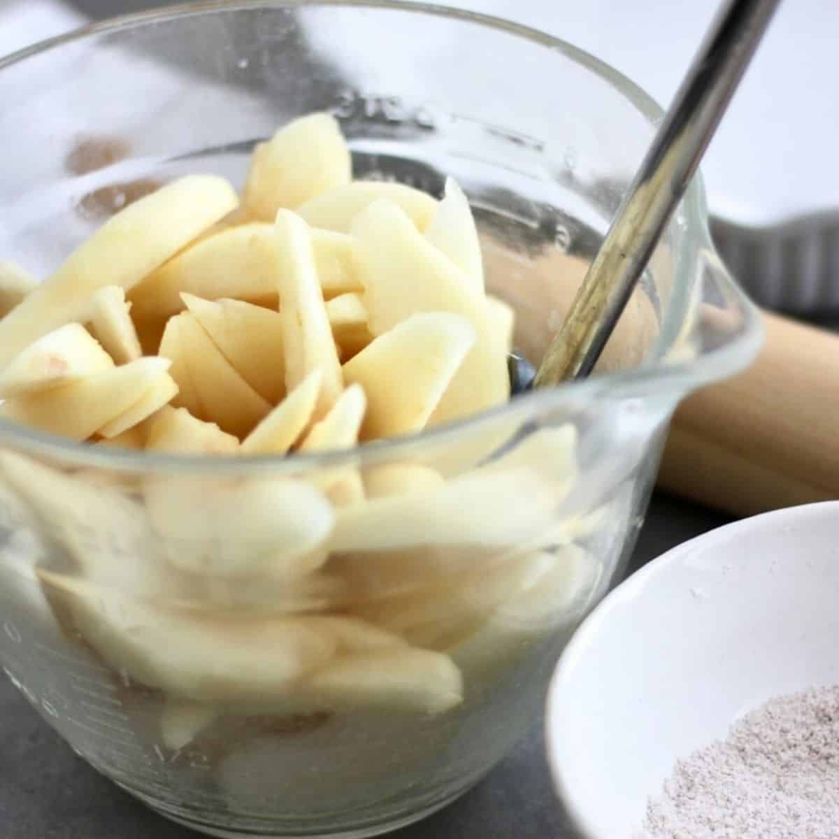 raw pear slices in large glass measuring bowl.