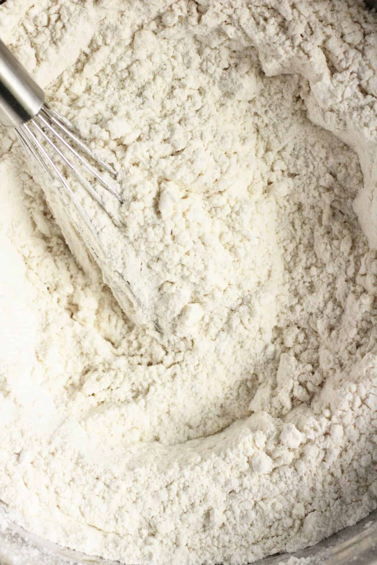 closeup shot of sorghum flour with a wire whisk in it.