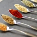 spoons of colorful spices in a diagonal row.