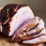 closeup of partially-sliced ham drizzled in honey glaze.