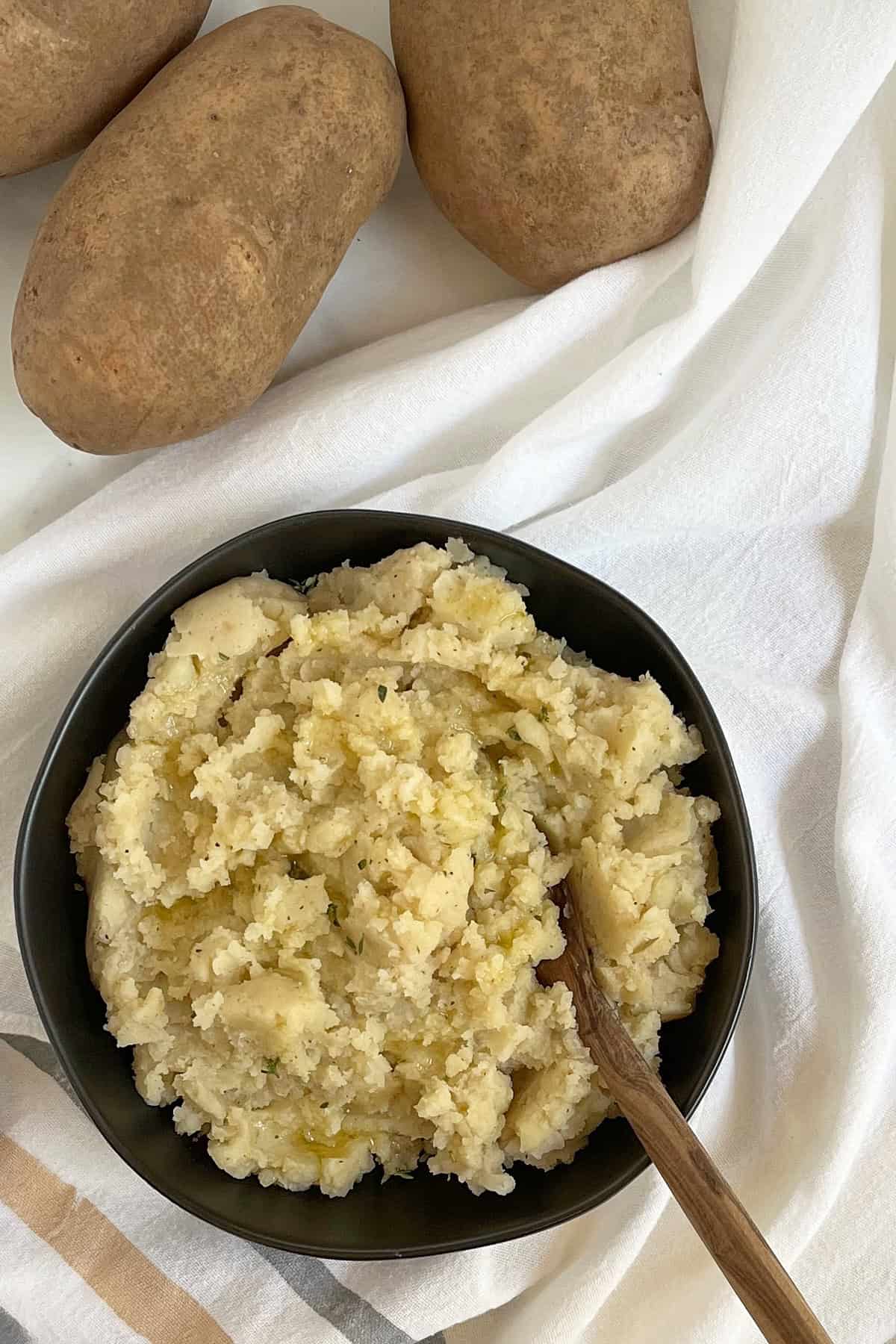 overhead view of mashed potatoes in black bowl.