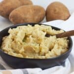 chunky mashed potatoes in black bowl.