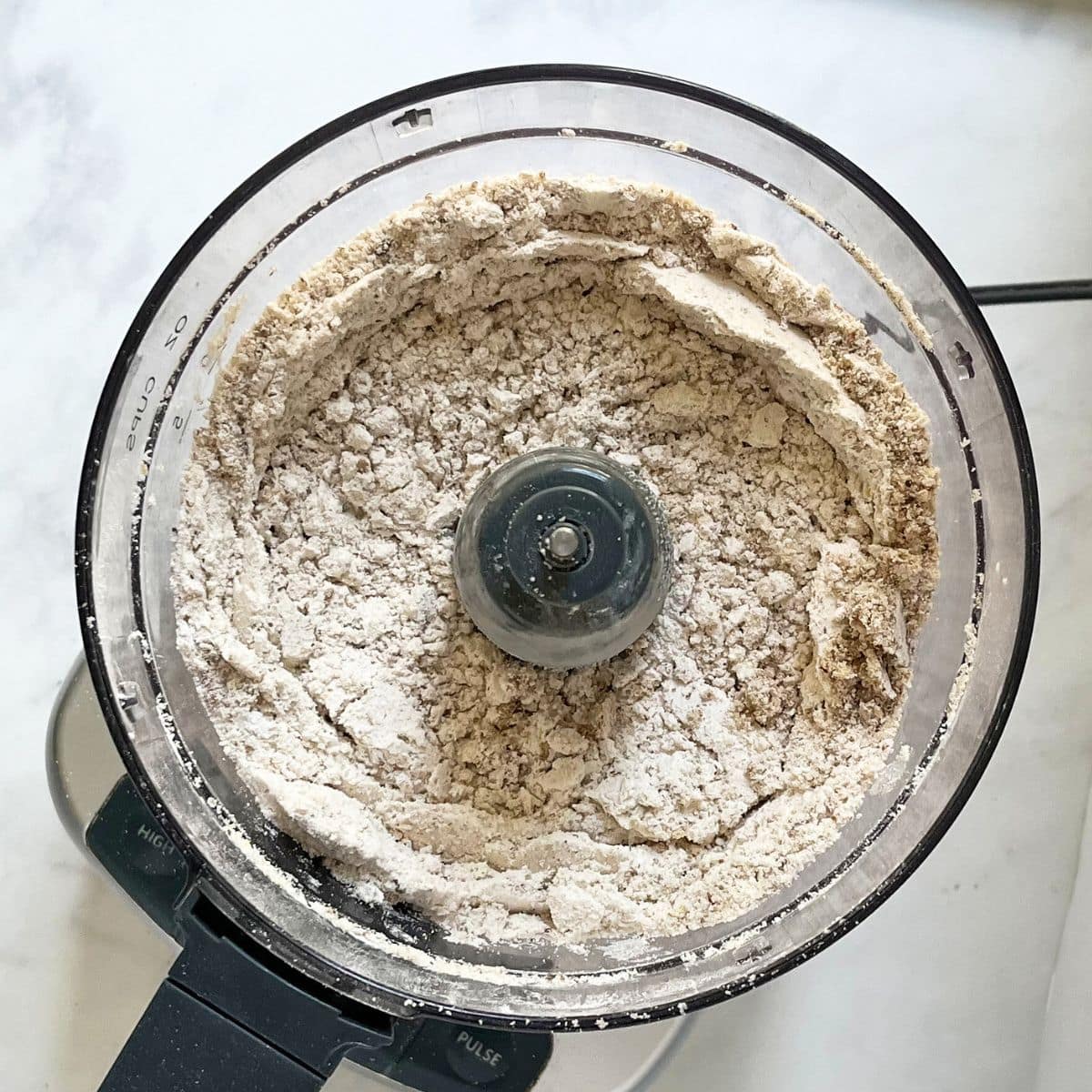 dry almond flour mixture in bowl of food processor.