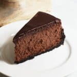 wedge of chocolate cheesecake served on white plate.
