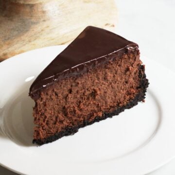 wedge of chocolate cheesecake served on white plate.