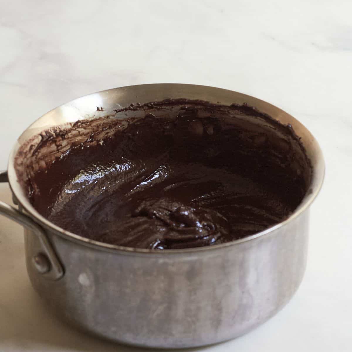 thick chocolate mixture glistening in a stainless steel saucepan.