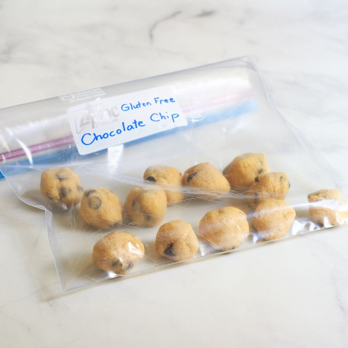 balls of uncooked cookie dough in a labeled freezer bag.