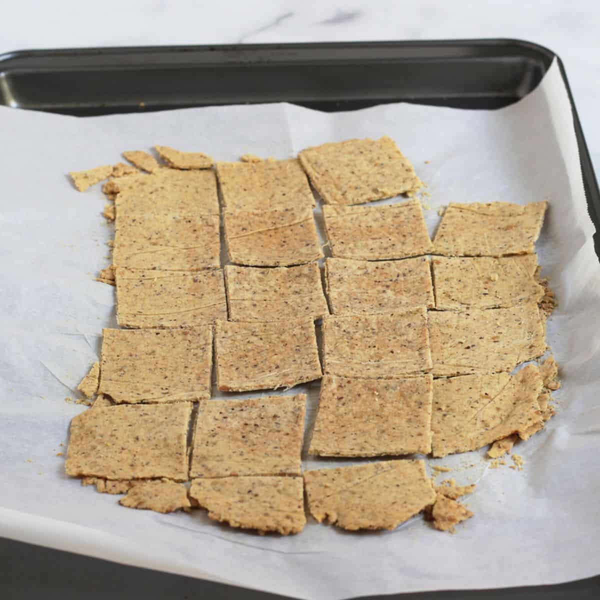golden, baked crackers on parchment-lined baking sheet.