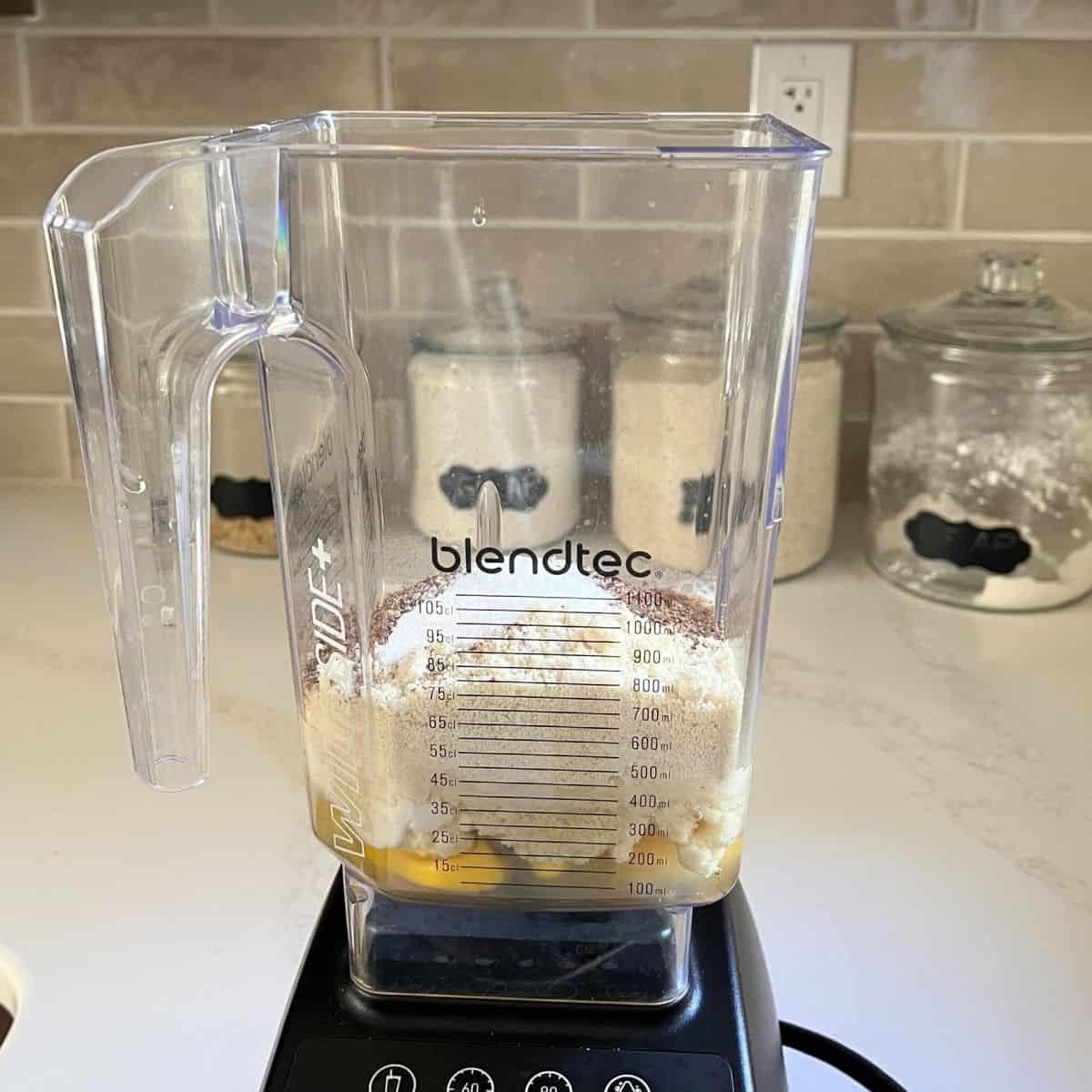 eggs and dry flour ingredients layered in Blendtec blender jar.