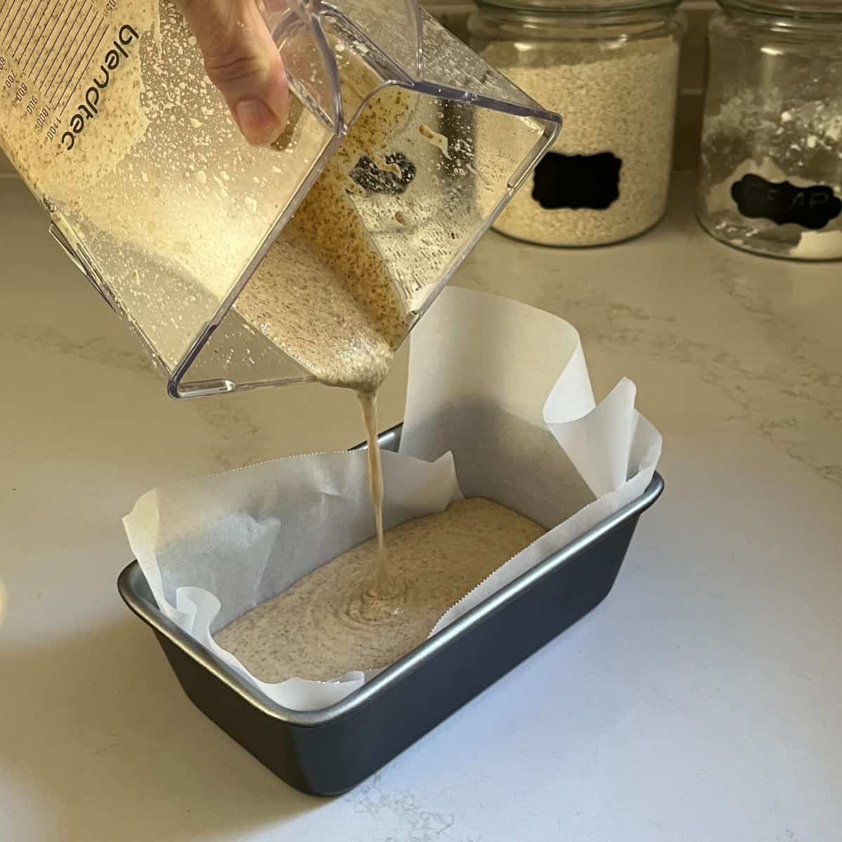 liquid batter is poured into loaf pan lined with parchment paper.